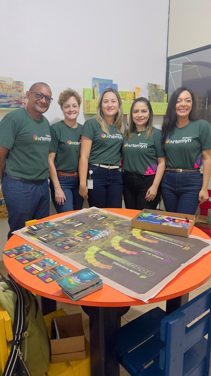 Registro real de um encontro, com cinco pessoas reunidas em torno de uma atividade educativa